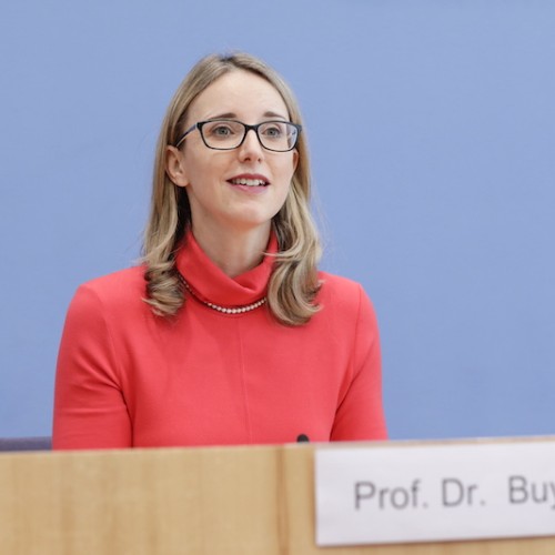Medizinethikerin Alena Buyx spricht auf diesem Foto während der Bundespressekonferenz für den Deutschen Ethikrat. Sie trägt eine rote Bluse, eine Brille und hat offene mittellange Haare