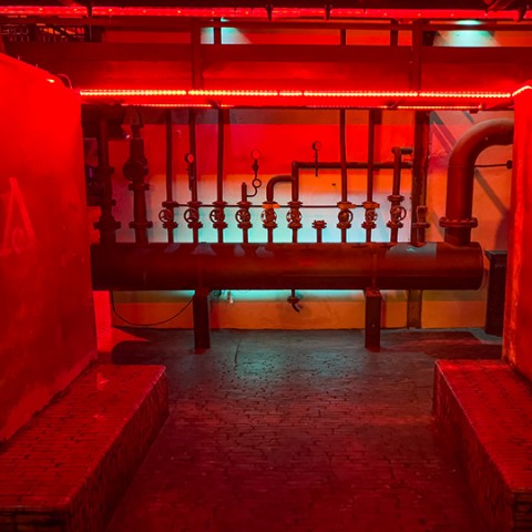 Sitzgelegenheiten neben alten Rohren und Ventilen im Arena Club