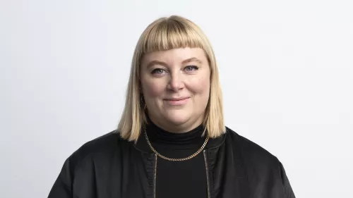 Anita Gohdes trägt eine schwarze Jacke, schulterlange Haare und eine Goldkette.