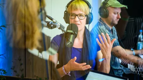 Eva Wolfangel als Gast bei der Aufnahme einer re:publicast-Folge. Sie trägt einen Kopfhörer und spricht in ein Mikrofon.