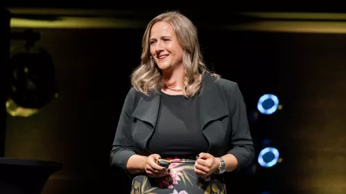Foto von Marisa Tschopp auf der Bühne. Sie trägt mittellange Haare und lächelt.