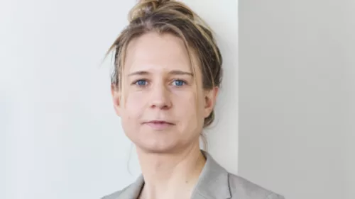 Foto von Maren Urner. Sie schaut direkt in die Kamera und trägt einen Blazer und ihre Haare in einem Dutt.