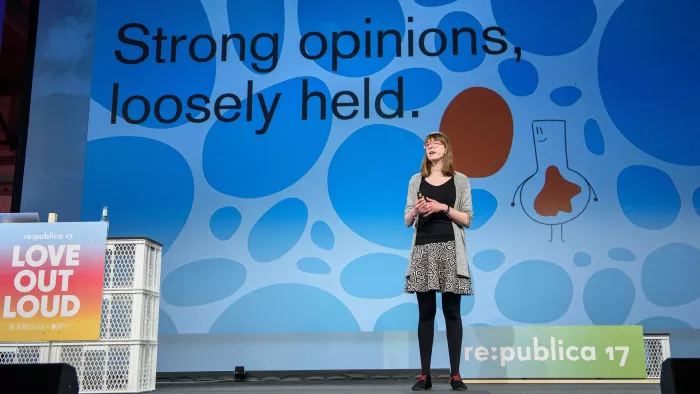 Lisa Charlotte Rost auf der Bühne der re:publica (#rp17) in Berlin. Hinter ihr auf der Leinwand ist zu lesen: „Strong opinions, loosely held.“
