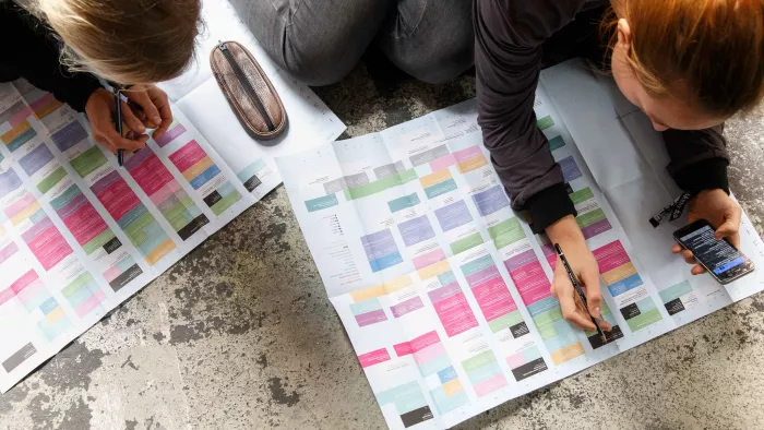 Teilnehmende der rp19 über den Programmplan gebeugt, markieren sich interessante Sessions.