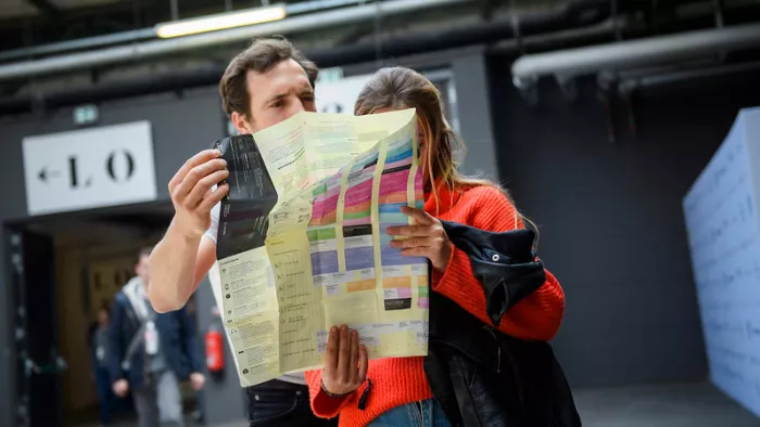 Zwei Teilnehmer:innen der re:publica schauen auf den Programmplan während der #rp19.