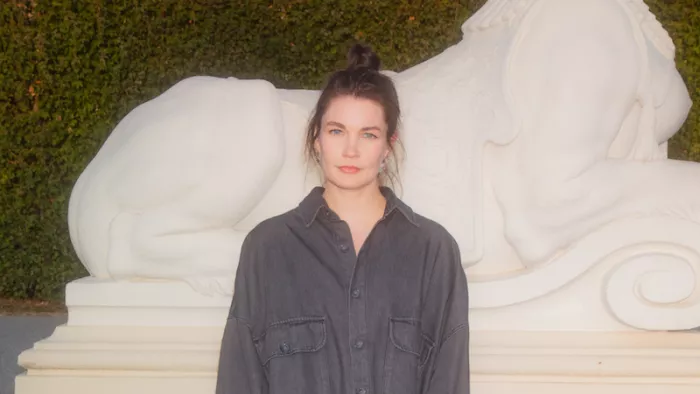 Das Foto zeigt Annekathrin Kohout. Sie trägt einen Dutt und steht vor einer Hecke mit einer Skulptur. Sie trägt eine Bluse.  Das Visual zeigt den Titel der Session "Ich meme, also bin ich". An den Seiten sind grafische Elemente aus dem diesjährigen Logo GenXYZ zu sehen. Darunter ist das Datum sowie die Location der republica 25 platziert.