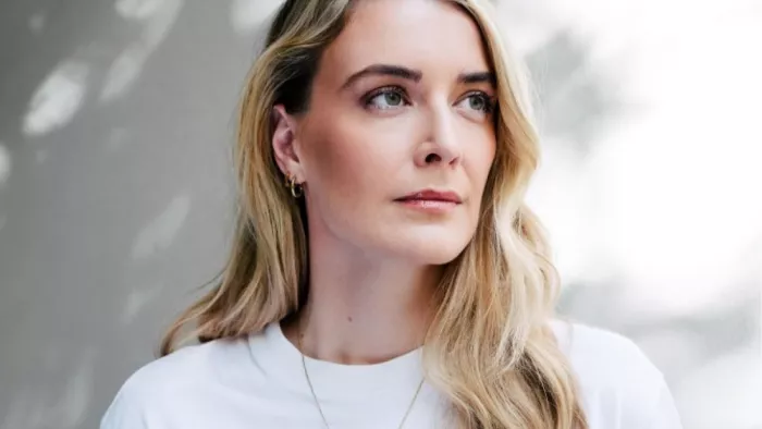 Das Foto zeigt Annika Brockschmidt. Sie trägt ein T-Shirt, lange Haare, eine Kette und schaut zur Seite