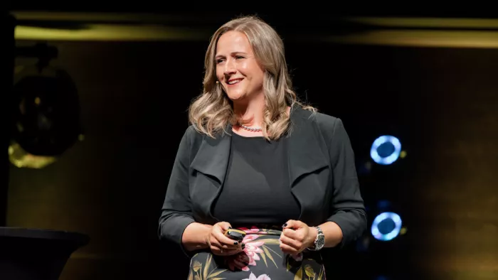 Foto von Marisa Tschopp auf der Bühne. Sie trägt mittellange Haare und lächelt.