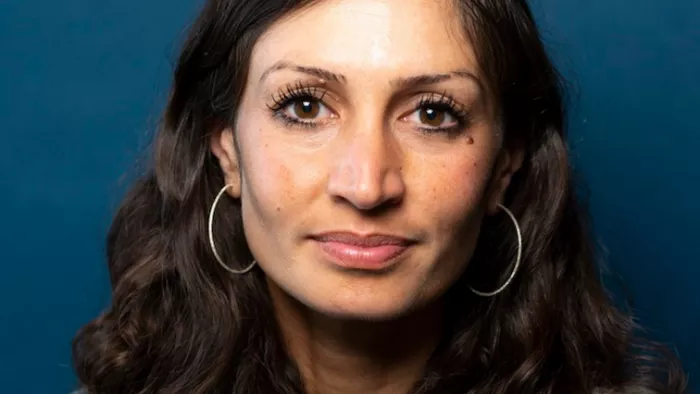 Foto von Gilda Sahebi. Sie blickt lächelnd in die Kamera, trägt mittellange Haare und Creolen