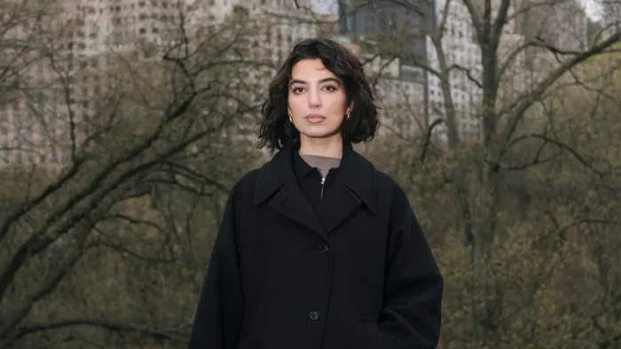 Foto von Aya Jaff. Sie steht im Central Park mit einem Wintermantel und schulterlangen Haaren.
