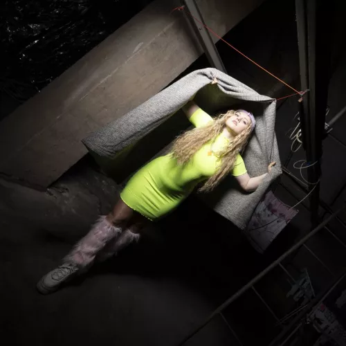 Foto der Künstlerin und Produzentin Aufmischen in grellgrünem Kleid und rosa Fellstulpen