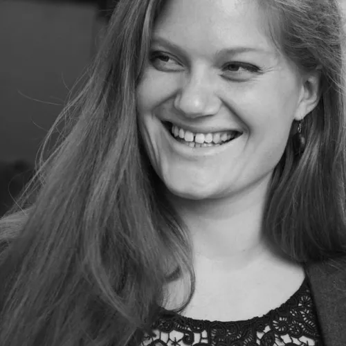 Schwarz-Weiß-Porträtfoto von Esther mit langen Haaren, lächelnd, Nahaufnahme des Gesichts.
