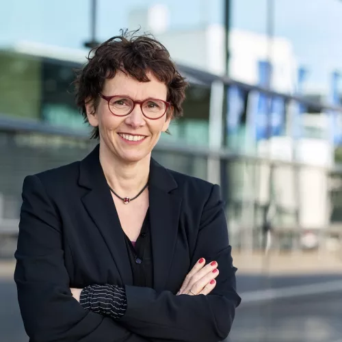 Portrait Almut Schnerring vor einer Glasfassade