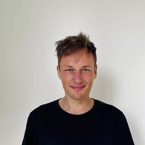 Profilbild einer Person mit schwarzem T-Shirt vor weißem Hintergrund
