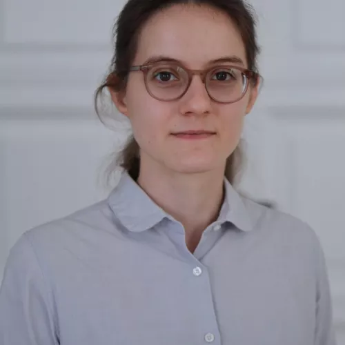 Charlotte Zeller stands in front of a neutral background.