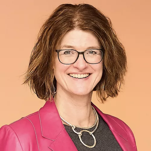 Hier ist ein Foto von Karen Funk zu sehen in einem pinkfarbenen Blazer.