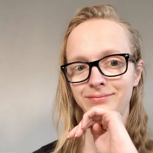 Frau mit Brille und Hand am Kinn im Portrait