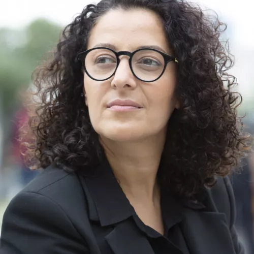Frau mit Brille schwarzer Blazer und schwarzes Hemd 