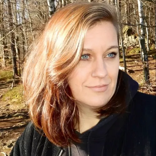 Portraitfoto einer blonden Frau mit schwarzer Jacke
