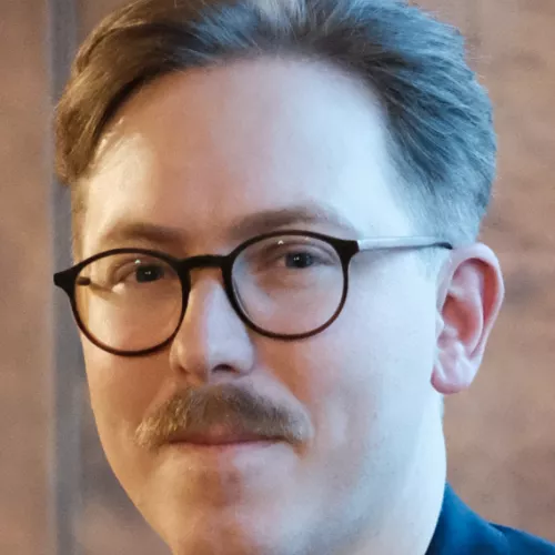 friendly looking guy with glasses and moustache
