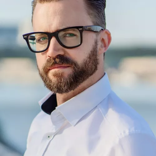 Marcel Lewandowsky, weißes Hemd, Brille, im Hintergrund der Rhein