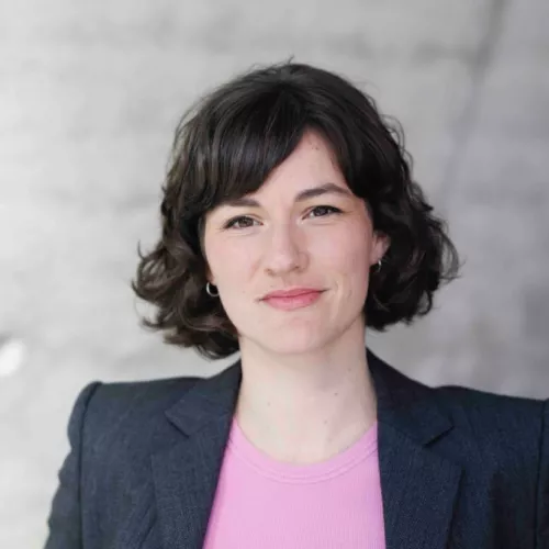 Marie Bröckling trägt einen schwarzen Blazer und schaut in die Kamera. Sie hat die dunklen Haare in einem lockeren Bob.