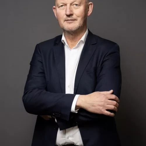 Porträt von einem Mann vor einem grauen Hintergrund