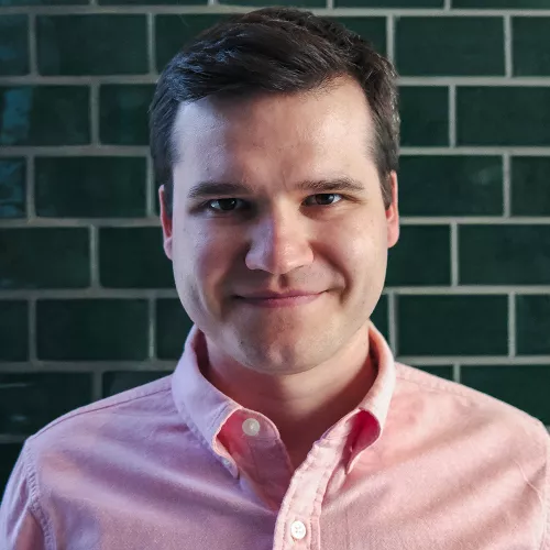 Portrait von Oskar Vitlif vor einer grün getäfelten Wand