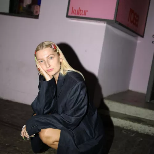 Isabelle Rogat sitzt in der Hocke und schaut in die Kamera. Sie hat blonde Haare.