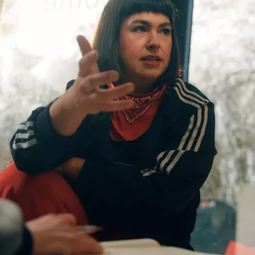 Teresa sitzt und erklärt etwas