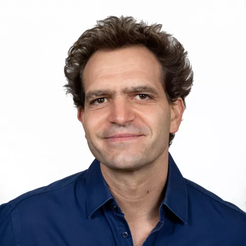 Portrait of a conference speaker looking at the camera against a neutral background