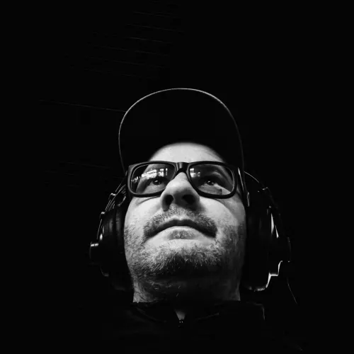 A picture of Fabrizio in black and white. He is wearing a cappie, glasses and headphones.