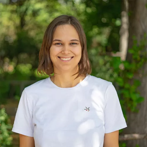 Portrait-Foto einer junges Frau in weißem T-Shirt vor grünem Hintergrund
