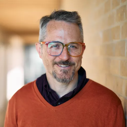 Smiling man in orange sweter